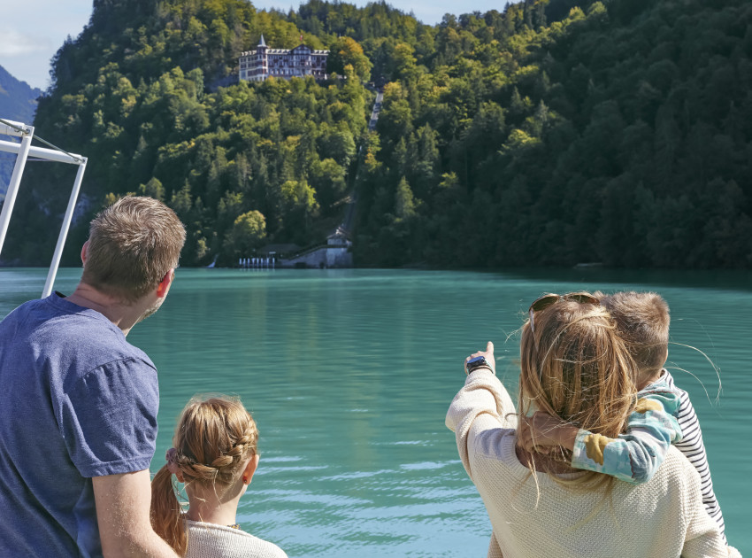 Familie auf Schiff auf Brienzersee, Mutter zeigt auf Grandhotel Giessbach