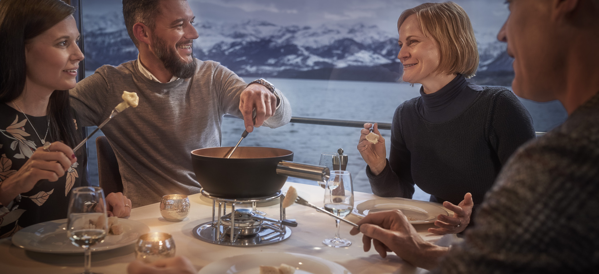 Gruppe von Freunden isst Fondue auf dem Schiff