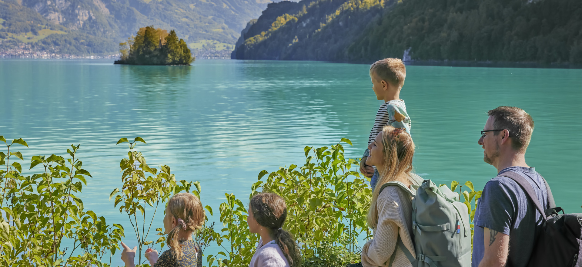 Familie am Uferweg Iseltwald-Giessbach mit türkisfarbenem Brienzersee im Hintergrund