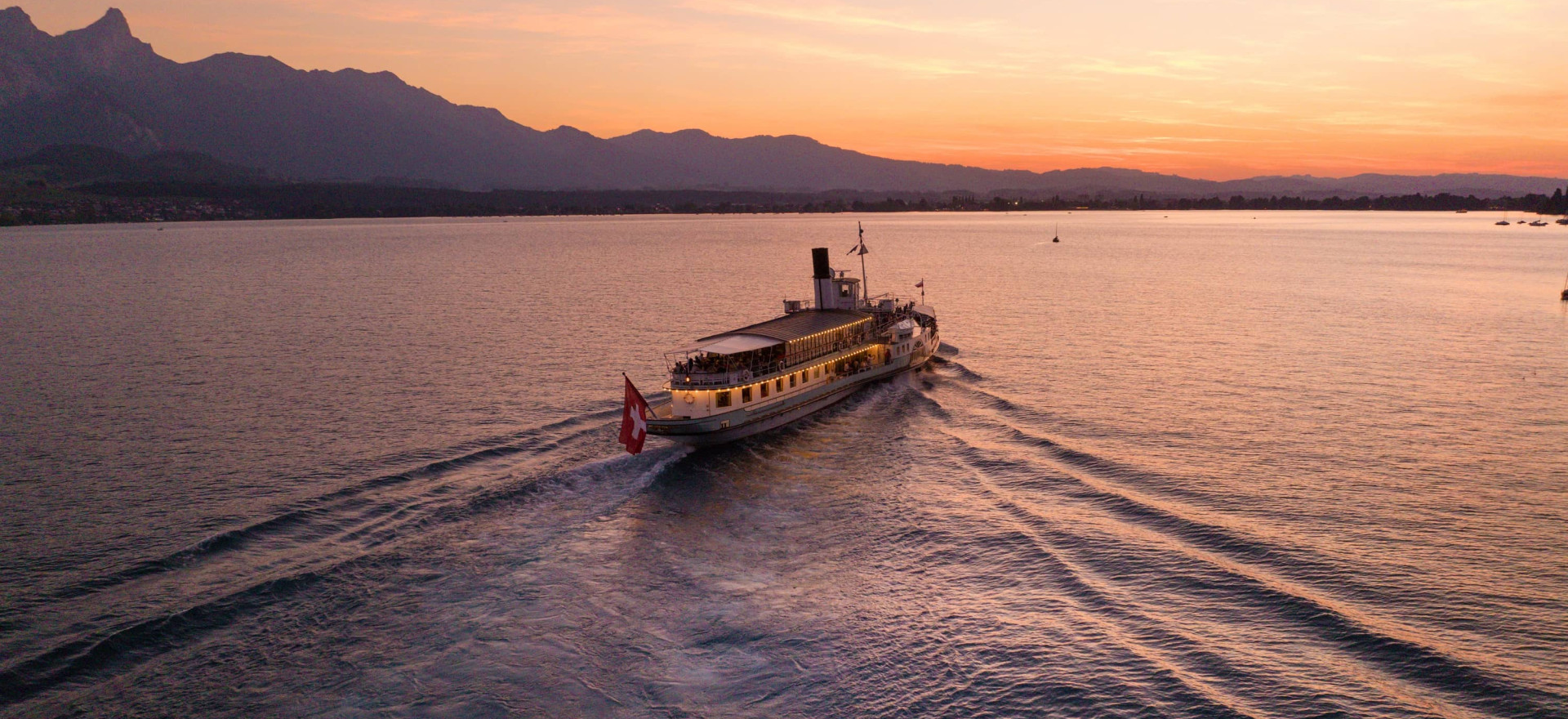 Das Dampfschiff Blümlisalp bei Sonnenuntergang auf dem Thunersee