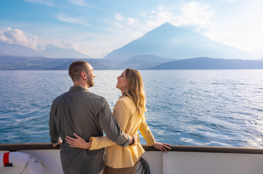 Ein Paar draussen auf dem Dampfschiff Blümlisalp mit Niesen im Hintergrund