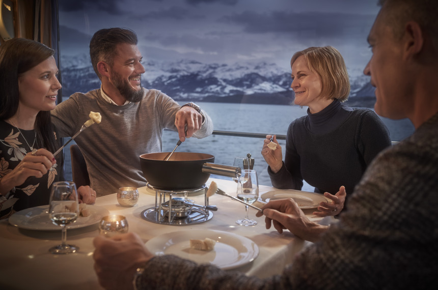 Gruppe von Freunden isst Fondue auf dem Schiff