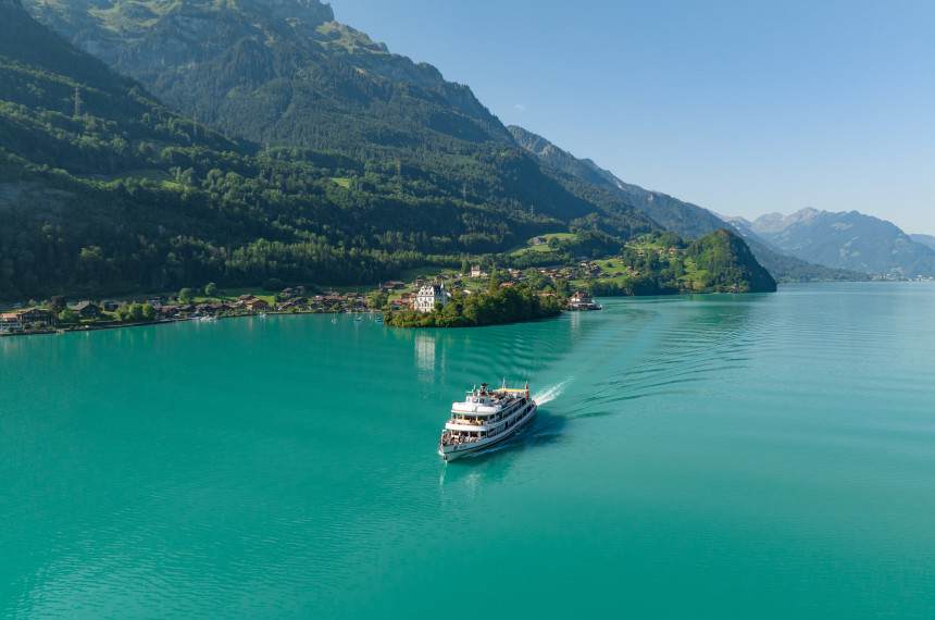 MS Brienz auf türkisfarbenem Brienzersee mit Iseltwald und Inseli im Hintergrund