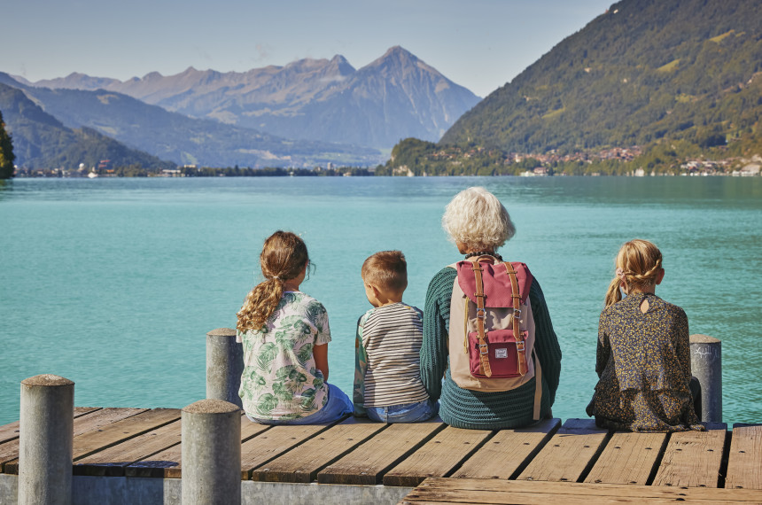 Grossmutter mit Grosskindern auf dem Steg in Iseltwald mit Blick auf Brienzersee und Berge